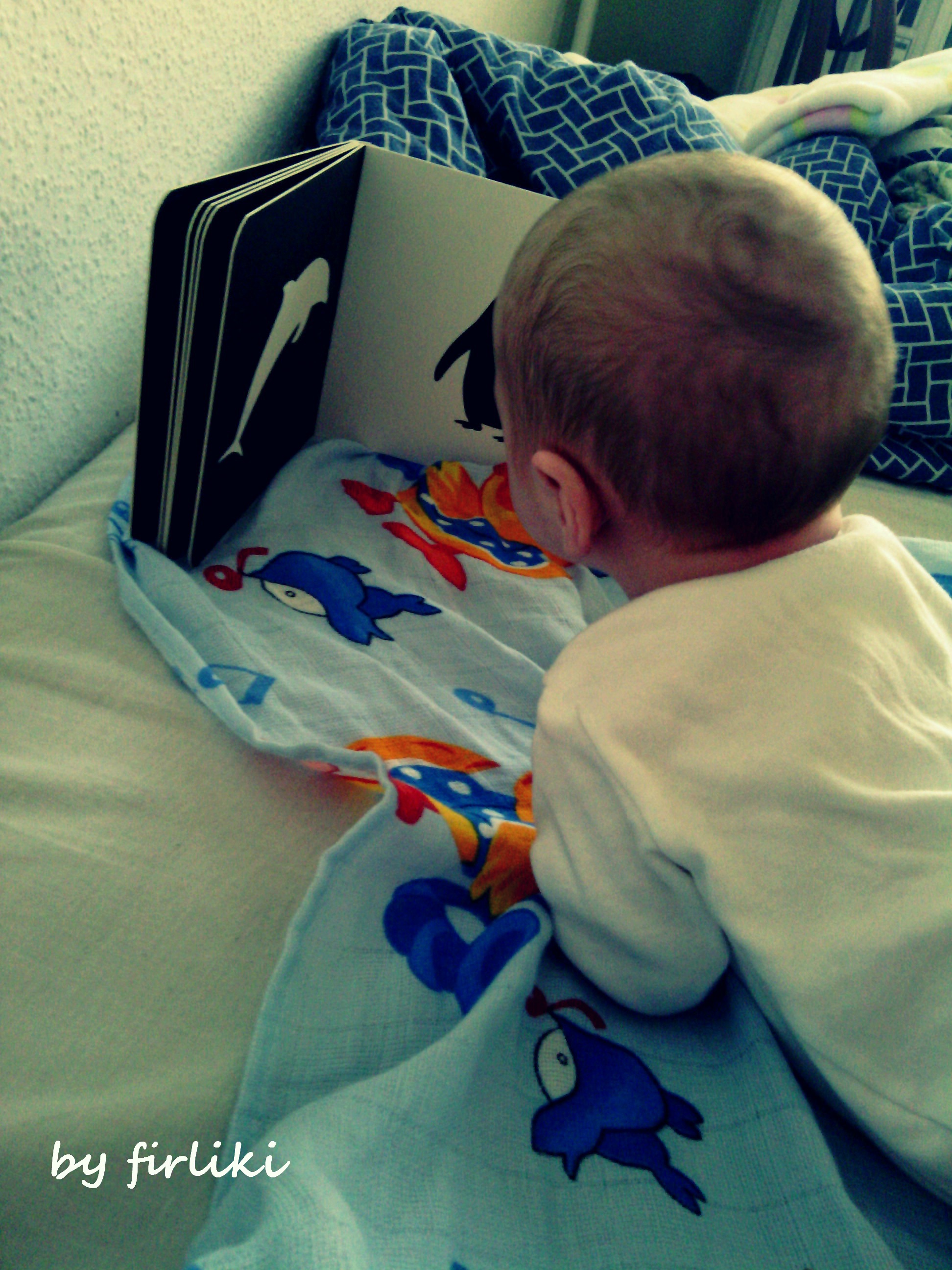 Pierwsze książki dla niemowlaków. Tymek czyta swoją pierwszą książkę.